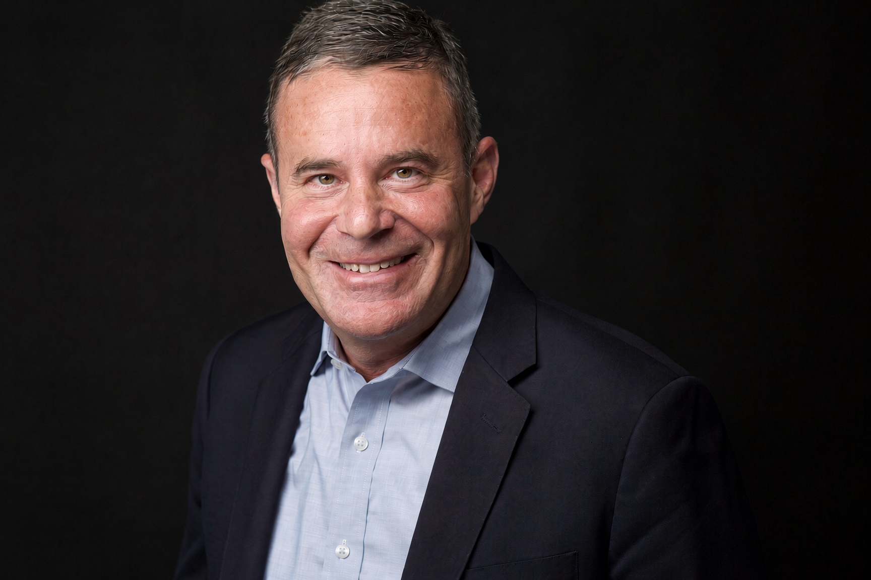 Portrait of Joe Daniels against a dark background